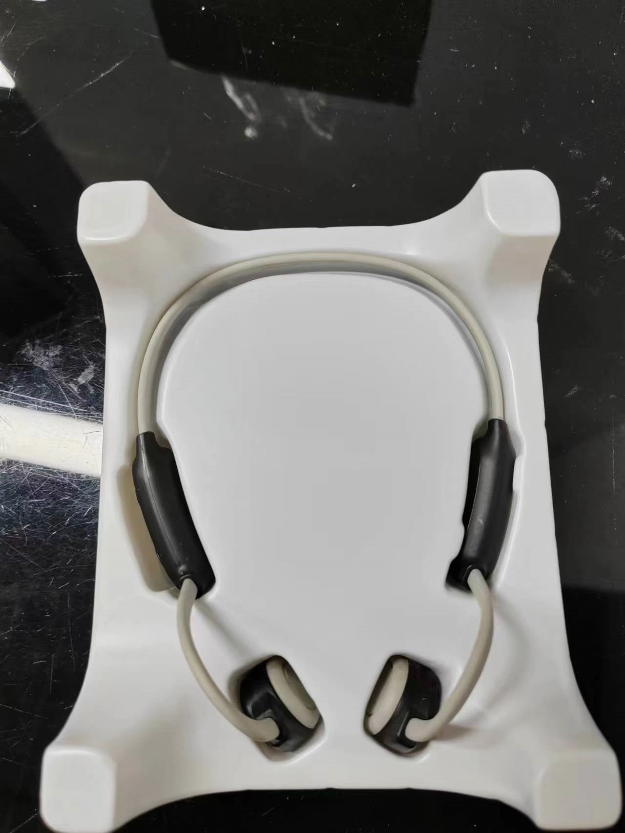 Personal bone conduction Bluetooth headset with ergonomic design in retail packaging.